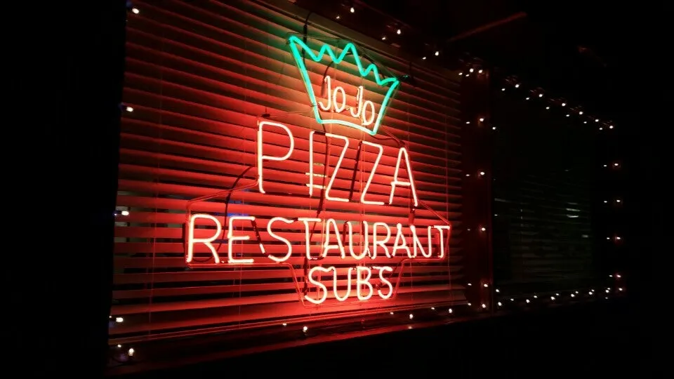 The crown-topped neon Pizza Restaurant Subs sign at Jo-Jo's